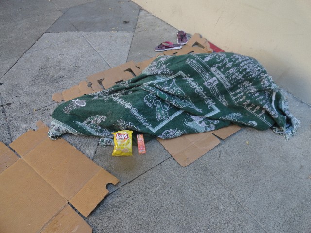 Homeless person sleeping with potato chips and cheese peanut butter crackers delivered